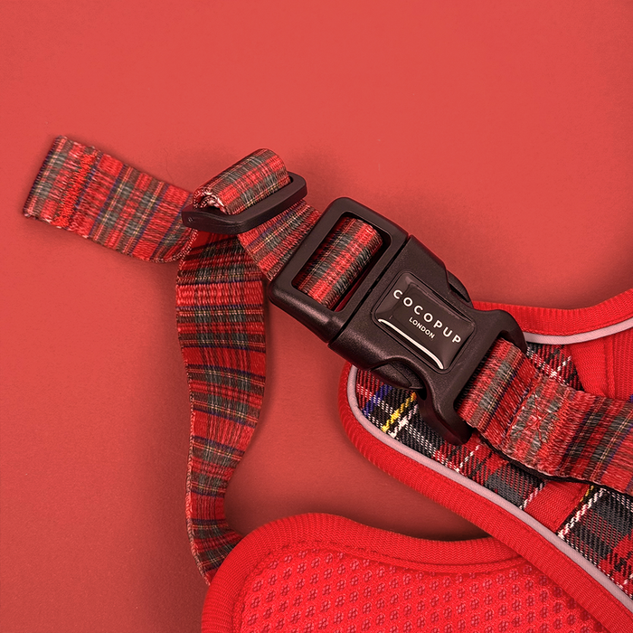 Tartan Explore Harness by Cocopup London with a black buckle, displayed on a matching red background.