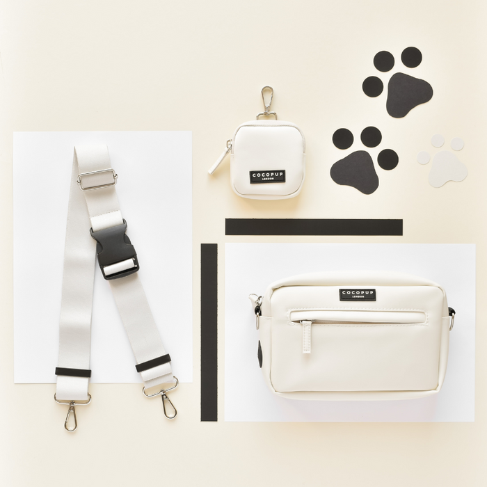 Cream Cocopup London dog walking bag with oyster white bum bag strap featuring black paw cutouts.