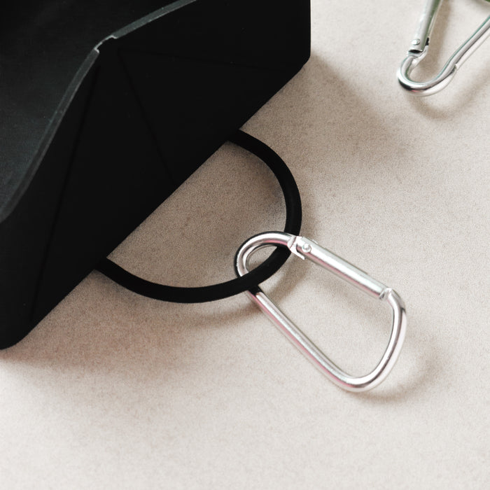 Black foldable travel bowl with a silver carabiner attached by a black band.