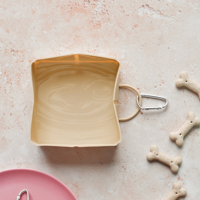 Nude Cocopup London foldable dog travel bowl with silver carabiner attached.