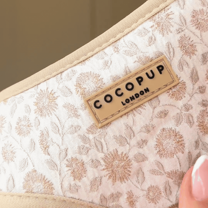 Floral print Luxe Adjustable Neck Harness by Cocopup London, strap held by hand, close-up view.
