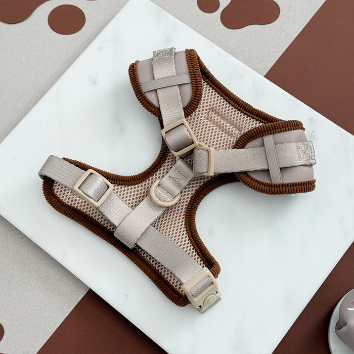 Beige and brown mesh adjustable neck harness by Cocopup London displayed on white marble background.