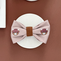 Pink dog bow tie with embroidered cow faces from Cocopup London.