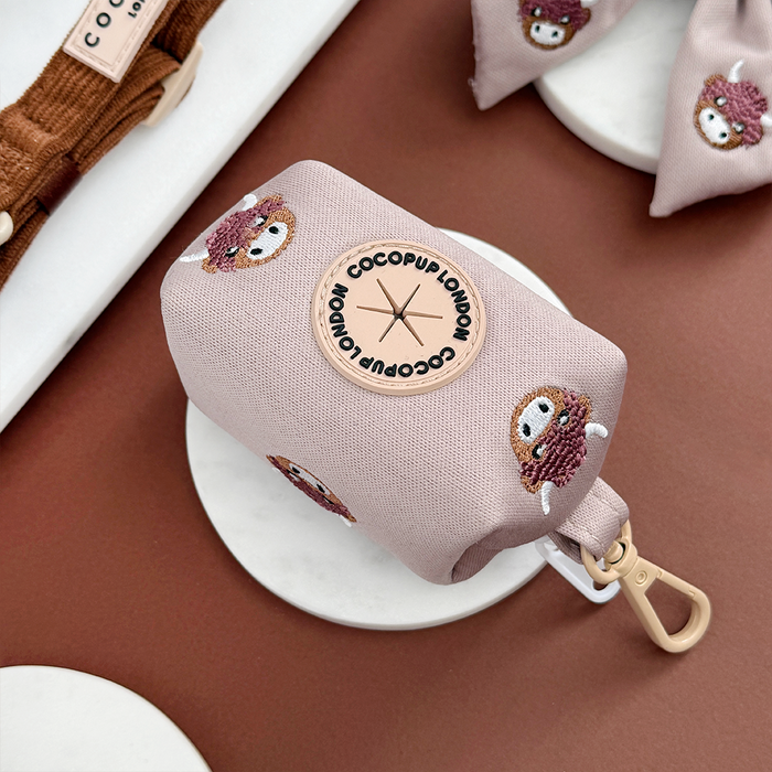 Brown poop bag holder with embroidered Highland cow face and Cocopup London logo.
