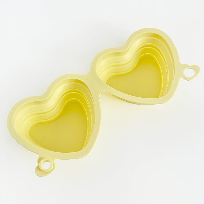 Butter yellow Cocopup London collapsible bowl with heart shape and two cavities.