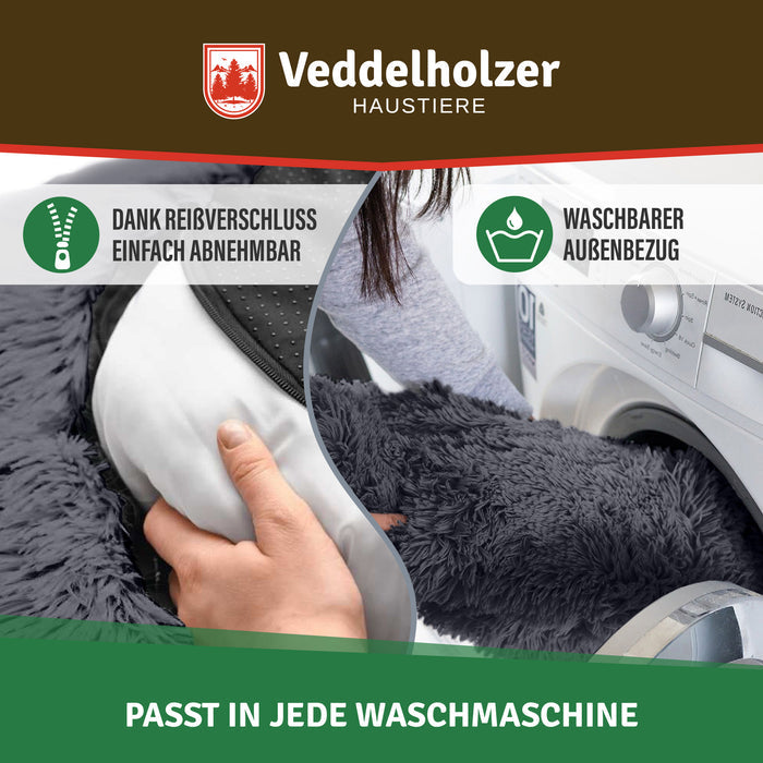 Hand zieht das weiße Innenkissen durch den Reißverschluss heraus, rechts wandert der dunkelgraue Bezug in die Waschmaschine