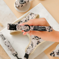 Hand holds an ivory and tortoiseshell-patterned dog collar by Cocopup London.