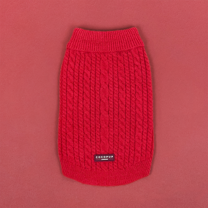 Cable knit dog jumper in mulled wine red, displayed on a matching red background.