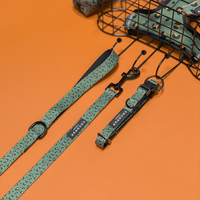 Khaki leopard print dog collar and green leopard print accessories on an orange background with a wire basket.