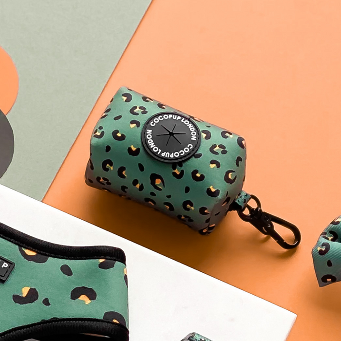 Khaki leopard print neoprene poop bag holder by Cocopup London with black clip, set against a multicolored background.