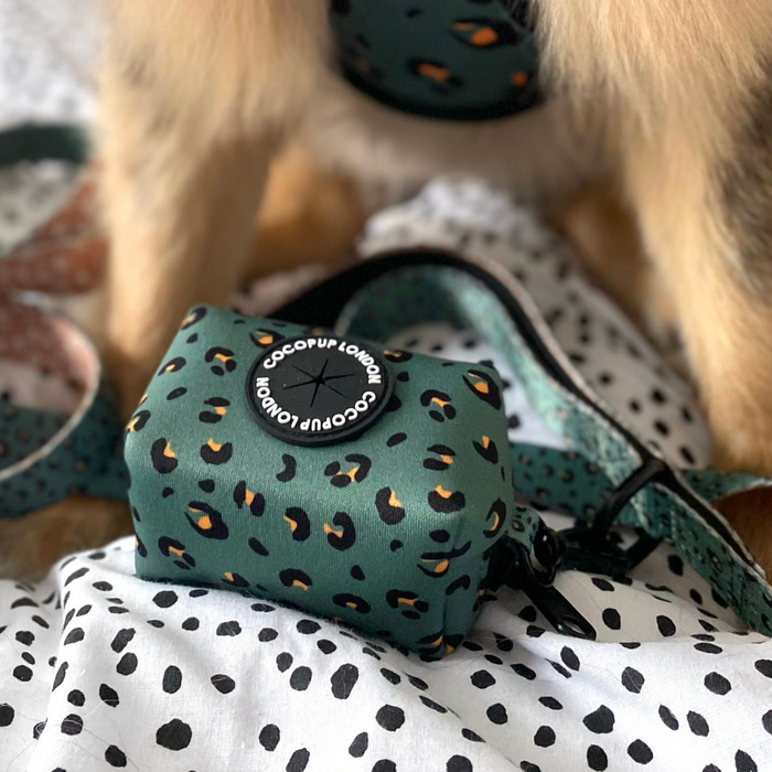 Khaki green neoprene Cocopup London leopard print poop bag holder with some dog fur visible in the background.