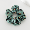 Khaki scrunchie with a brown and black leopard print pattern.
