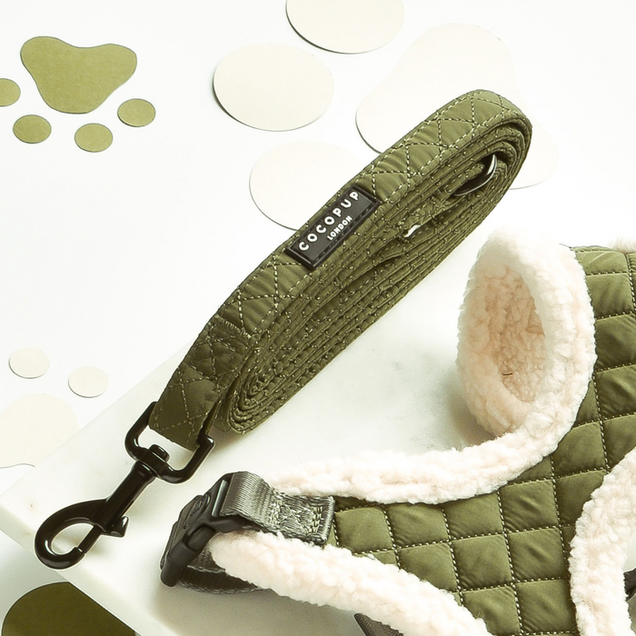 Khaki quilted dog harness, lead, and collar set from Cocopup London on a white surface with paw prints.