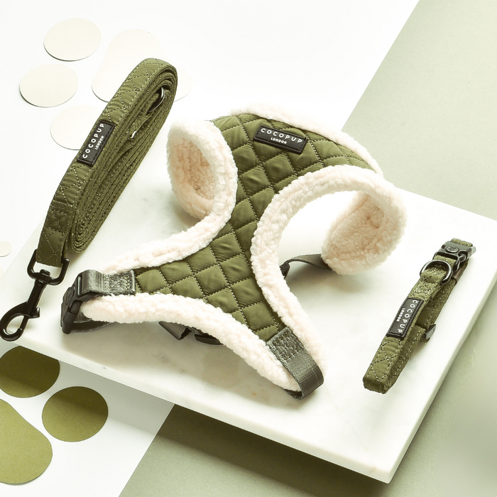 Khaki quilted harness, lead, and collar set with white fleece lining displayed on a marble surface.