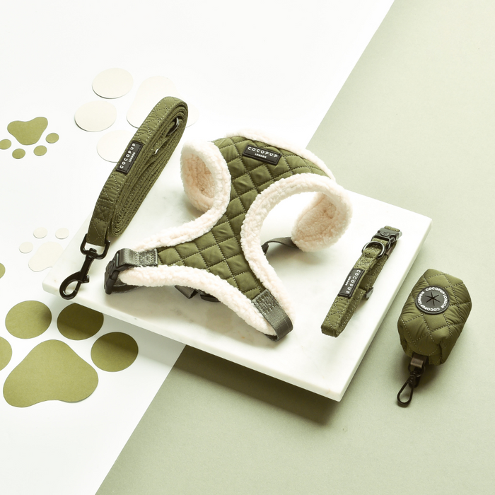 Khaki quilted harness set by Cocopup London, includes adjustable collar, leash, and waste bag holder on a white surface.