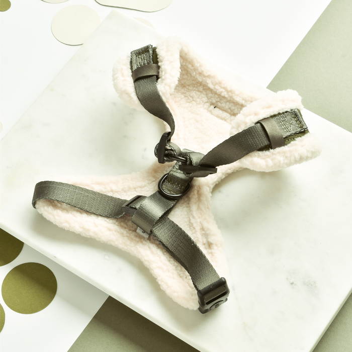Khaki quilted Cocopup London harness with black straps on a white marble surface.