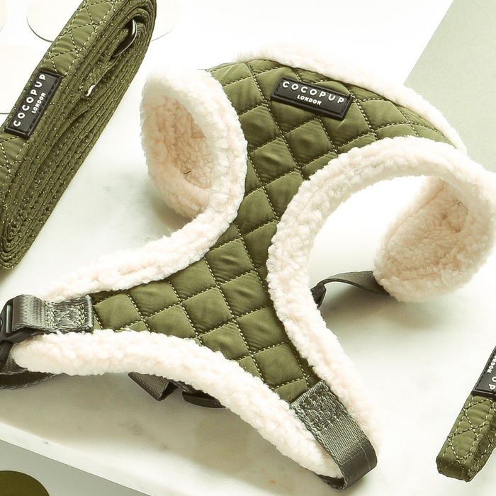 Khaki quilted dog harness with adjustable neck and white fleece lining on a white surface.