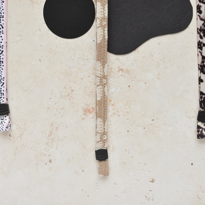 Mocha Flower lanyard by Cocopup London with floral patterned straps, displayed on a stone surface.