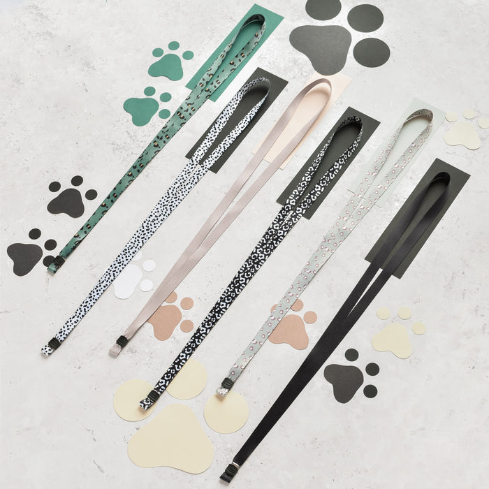 Nude Cocopup London lanyard with colorful paw print pattern laid flat.