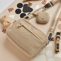 Cocopup London large teddy-texture dog walking bag with accessories on a beige surface with abstract shapes.