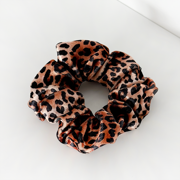 Leopard print fabric scrunchie with Cocopup London tag on a white surface.