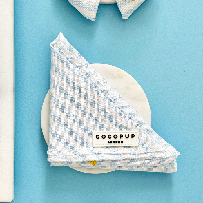 Yellow lemon-patterned bandana by Cocopup London on a round white surface.