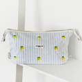 Expandable makeup bag with blue stripes and lemon print, by Cocopup London, displayed on a white shelf.