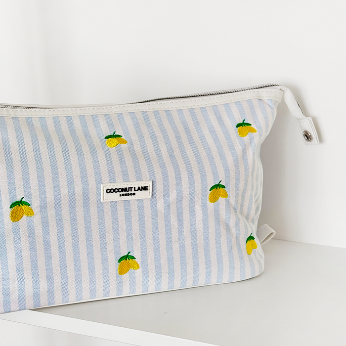 Expandable makeup bag with blue and white stripes, decorated with embroidered lemons.