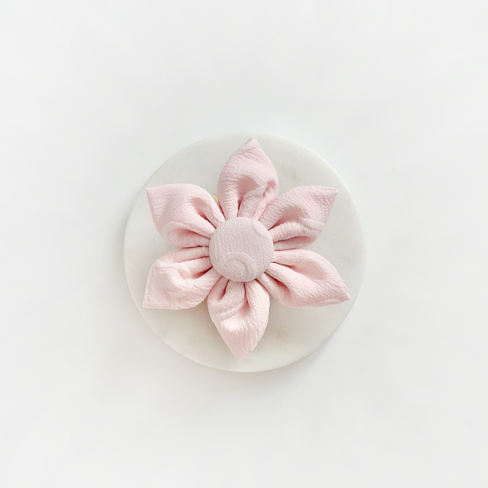 LUXE baby pink heart-shaped collar flower by Cocopup London on a round white surface, viewed from above.