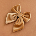 Mocha velvet sailor bow tie with four loops, displayed on a matching tan background.