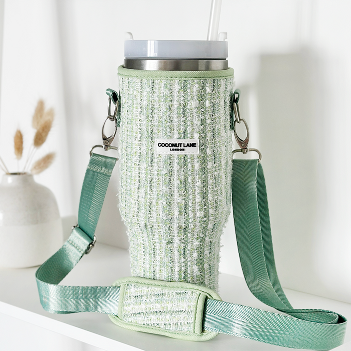 Green tweed tumbler carry case with adjustable strap, holding a lidded cup and straw.