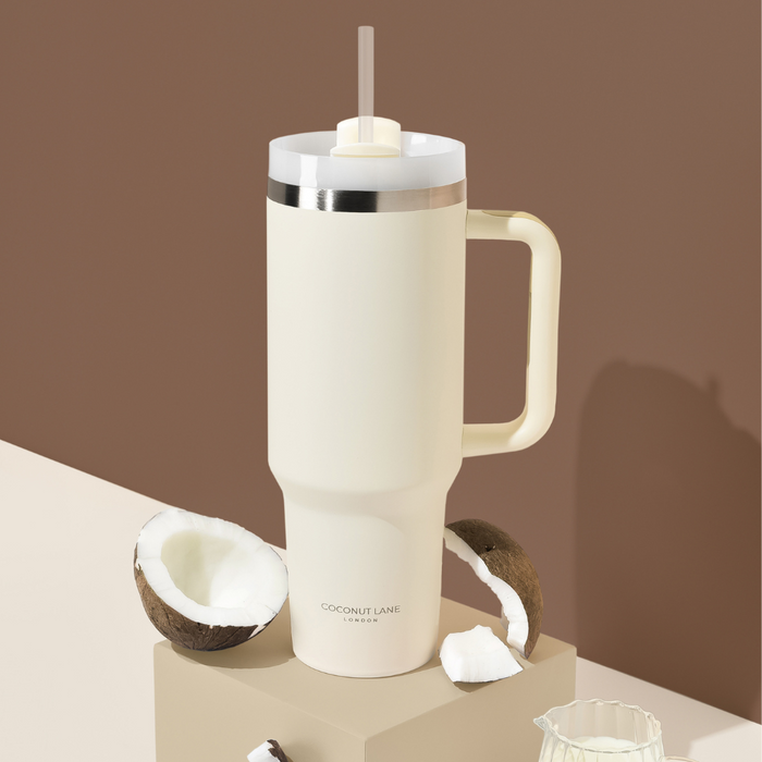 Cream-colored stainless steel tumbler with handle and straw, Cocopup London branding visible.
