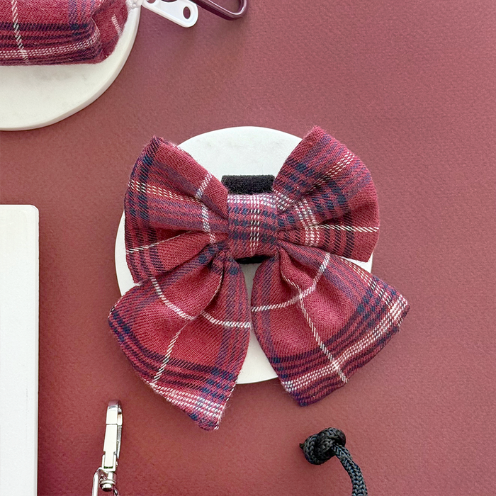 Plaid mulberry dog sailor bow tie on a maroon background.