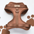 Brown adjustable dog neck harness by Cocopup London on a white background with brown paw print patterns.