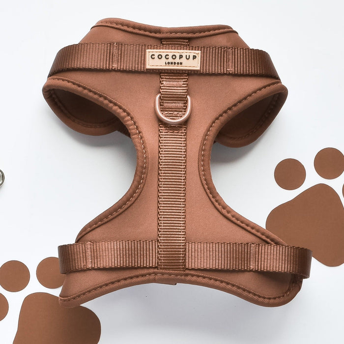 Brown adjustable dog neck harness by Cocopup London on a white background with brown paw print patterns.