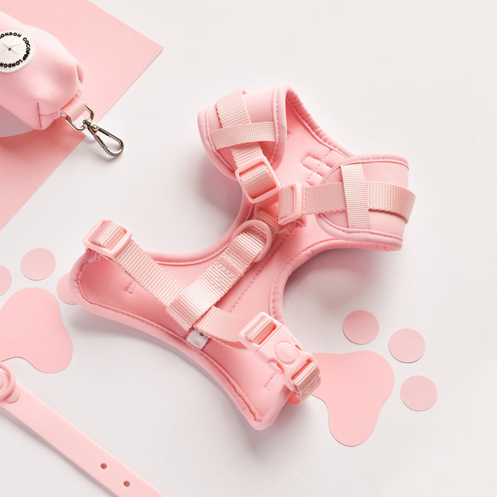 Pink Cocopup London harness, leash, and waste bag holder set on a white surface with pink paw prints.