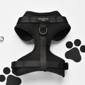 Black adjustable dog harness with paw print pattern, no-pull design by Cocopup London.