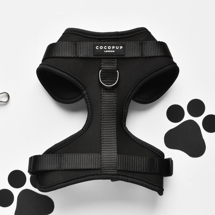 Black adjustable dog harness with paw print pattern, no-pull design by Cocopup London.
