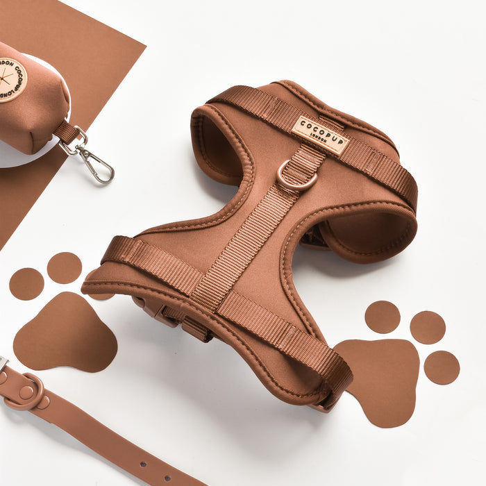 Brown adjustable dog harness, lead, collar, and poop bag holder with paw print cutouts from Cocopup London.