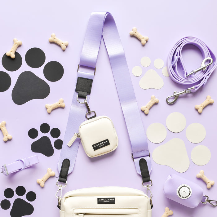 A purple bag from Cocopup London's NAKD collection, featuring a Parma Violets-themed strap adorned with dog bones. Perfect as a stylish Dog Walking Bag.