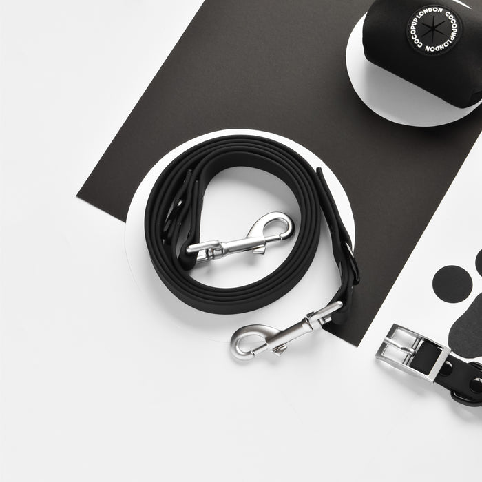 Cocopup London black leash with attached waste bag dispenser, sleek design and smooth finish.