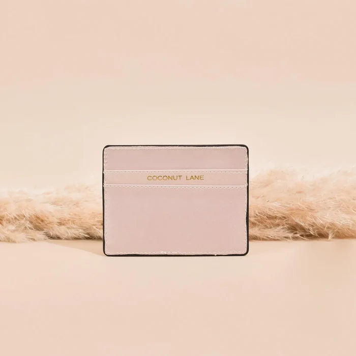 Beige NAKD Nude card holder with gold Coconut Lane text on the front, set against a soft beige background.