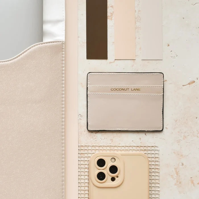 Beige card holder, matching phone case, and neutral color swatches arranged on a flat surface.