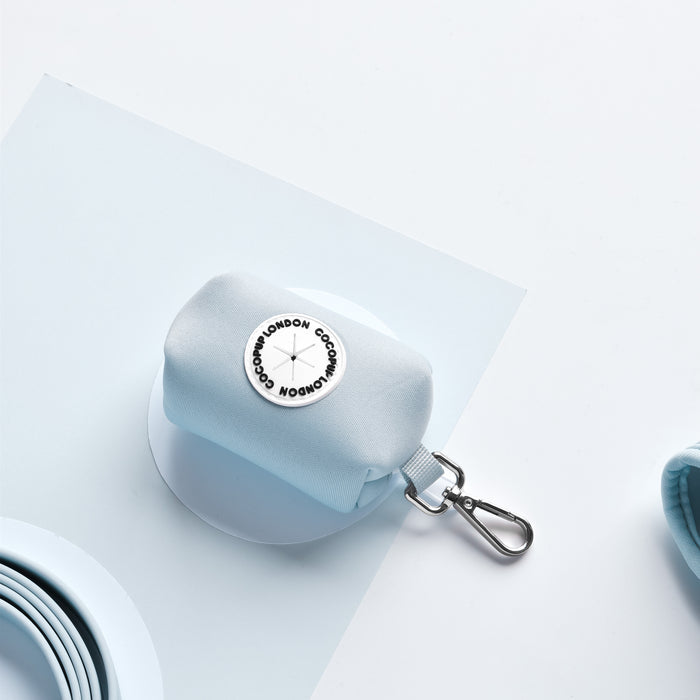 Light blue Cocopup London poop bag holder with round logo patch and silver metal clip.