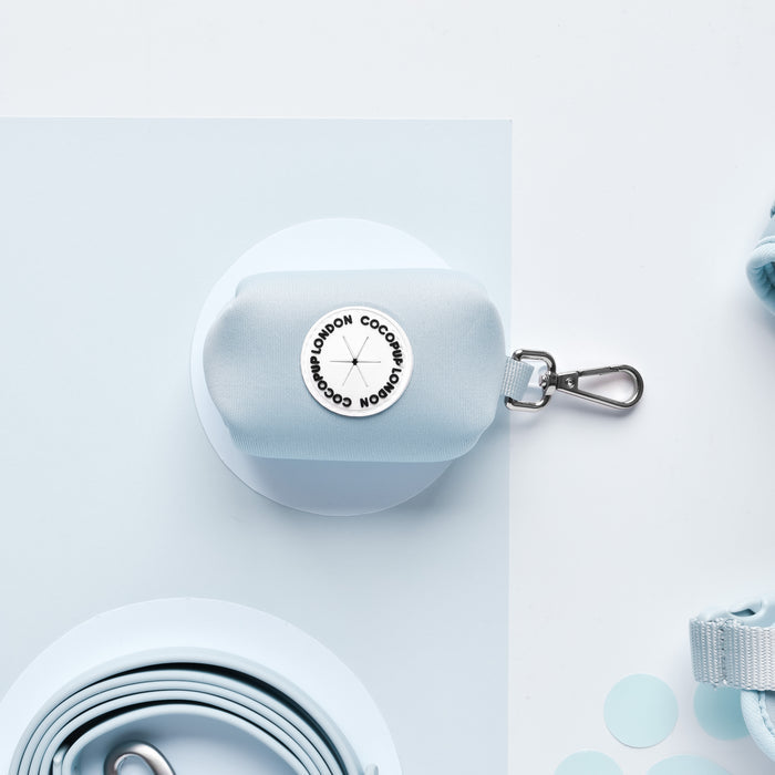 Light blue Cocopup London poop bag holder with metal clip and visible Coconut London label.