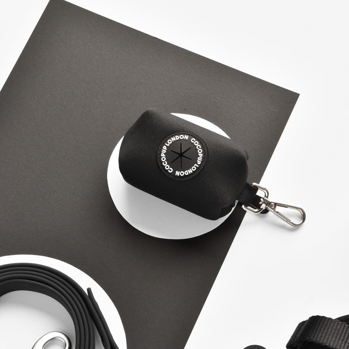Black NAKD poop bag holder with metal clip and round logo, by Cocopup London.