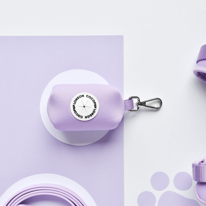 Parma violet Cocopup London NAKD poop bag holder with a silver clip, shown on a pastel purple background.