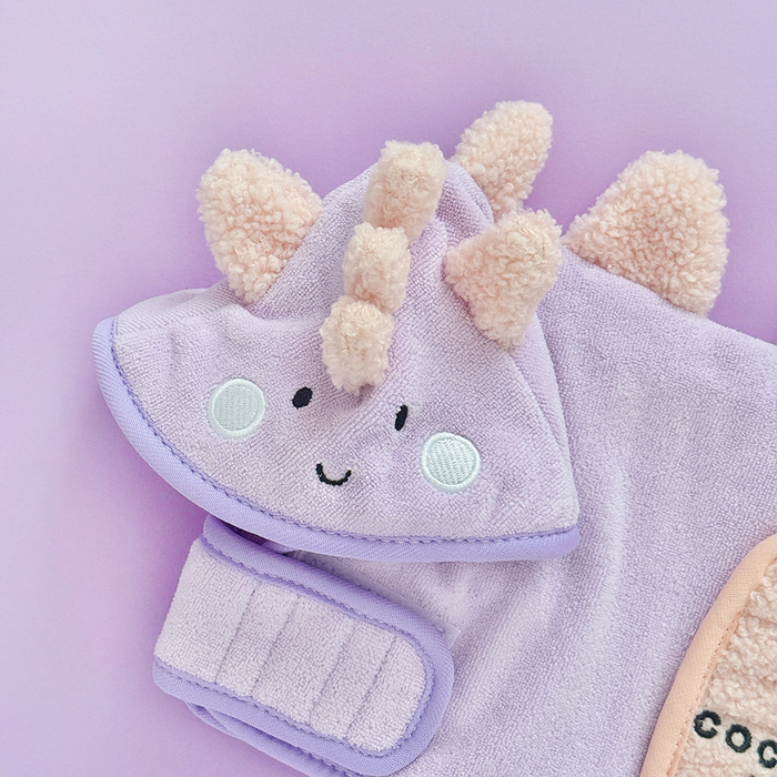 Purple kids drying robe with a dino face, cream fluffy ears, and a horn.