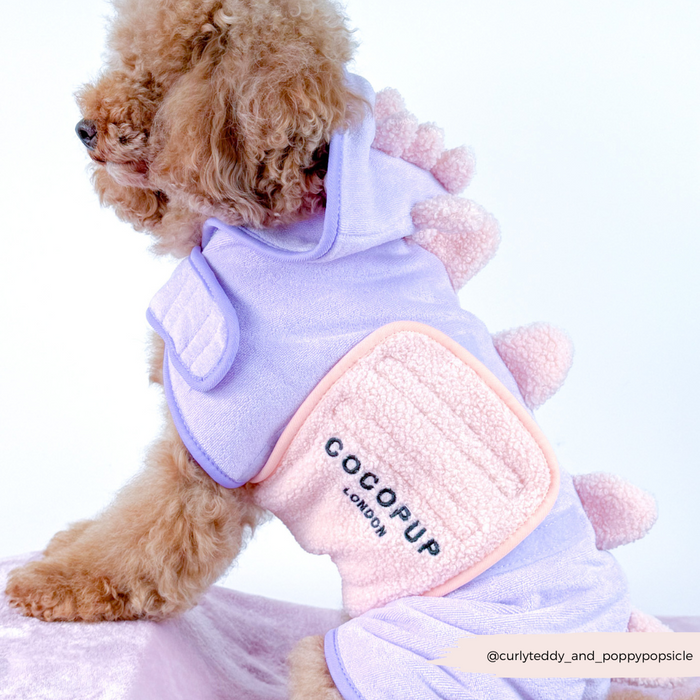 Fluffy dog in a green Cocopup London Nessie Dino drying robe with soft spikes along the back.