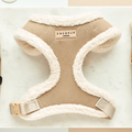 Nude adjustable neck harness with fluffy edges by Cocopup London, displayed on a marble surface.